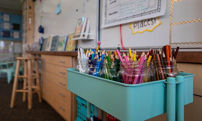 clean classroom with neatly arranged school supplies and colorful bins